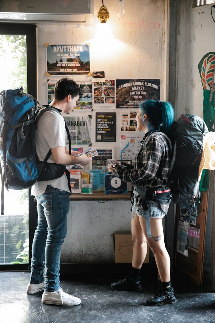 stats-img A young couple with backpacks examining travel brochures indoors, planning their next urban adventure.